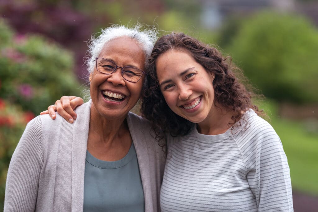 senior mother and daughter walk and talk together outside