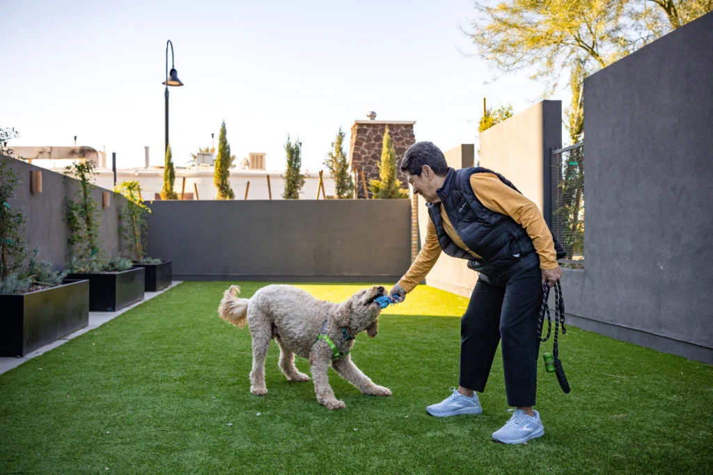 Senior woman playing with dog at Clarendale Arcadia 