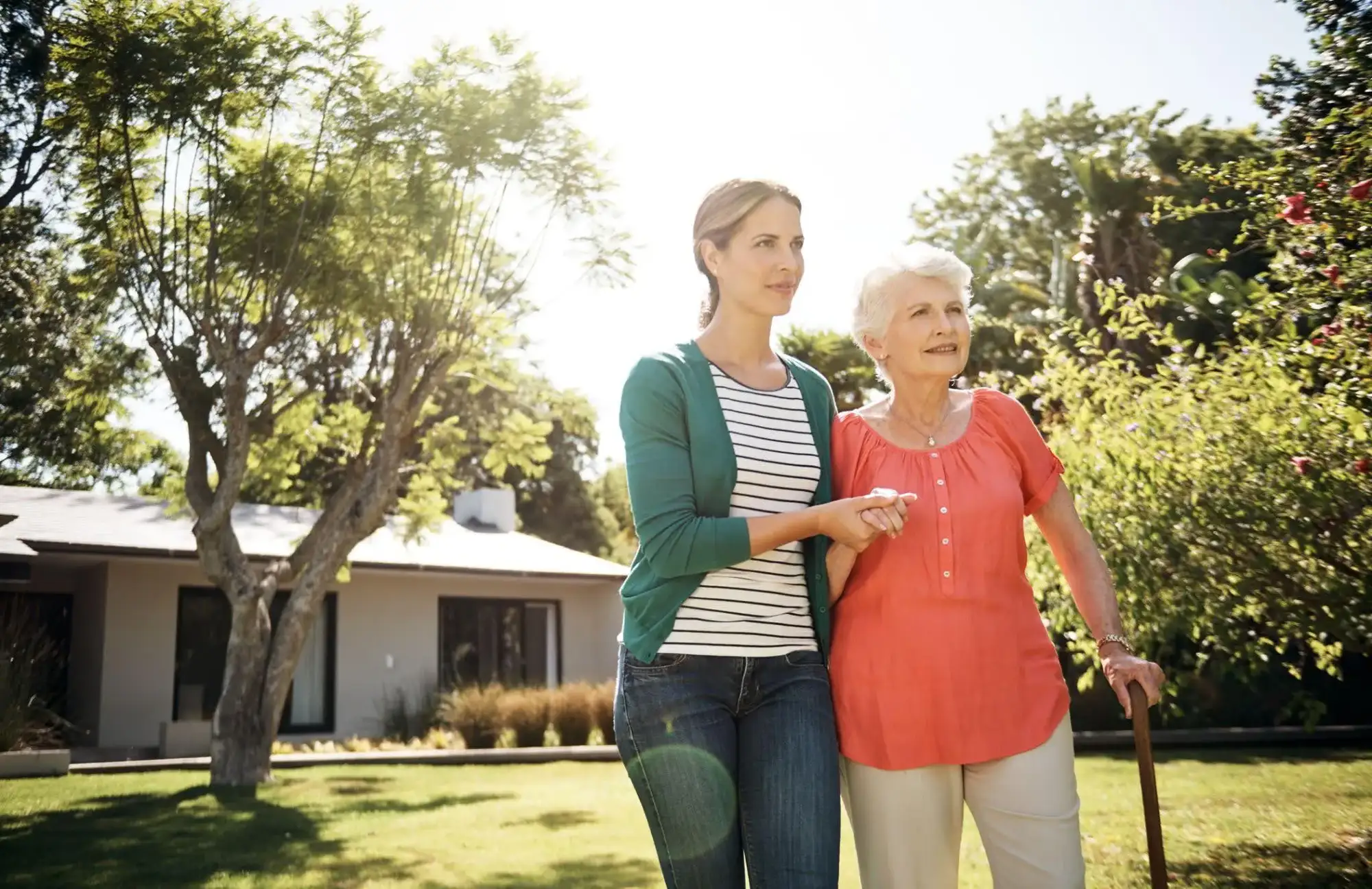An adult daughter walking with her senior mother and talking about searching for "memory care near" in Phoenix, AZ, for options like Clarendale Arcadia.