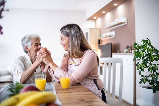 A senior mother with memory loss holding hands with her adult daughter from her home at Clarendale Arcadia, which offer a new program "SafelyYou®" for advanced memory care in Phoenix, AZ.